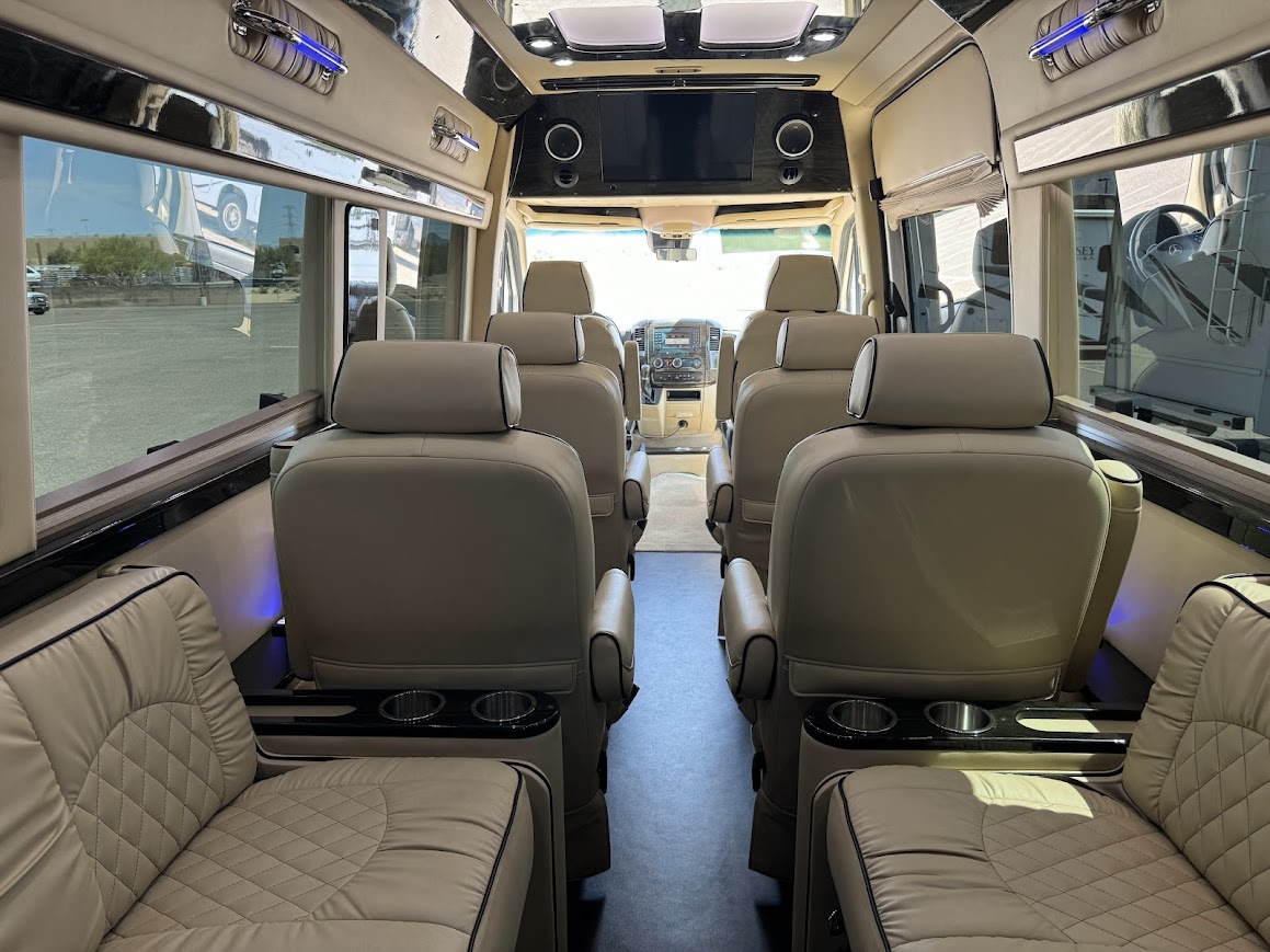 Luxury RV rental interior: Plush, light-colored leather seating and spacious aisle create a premium travel experience. — photo 14