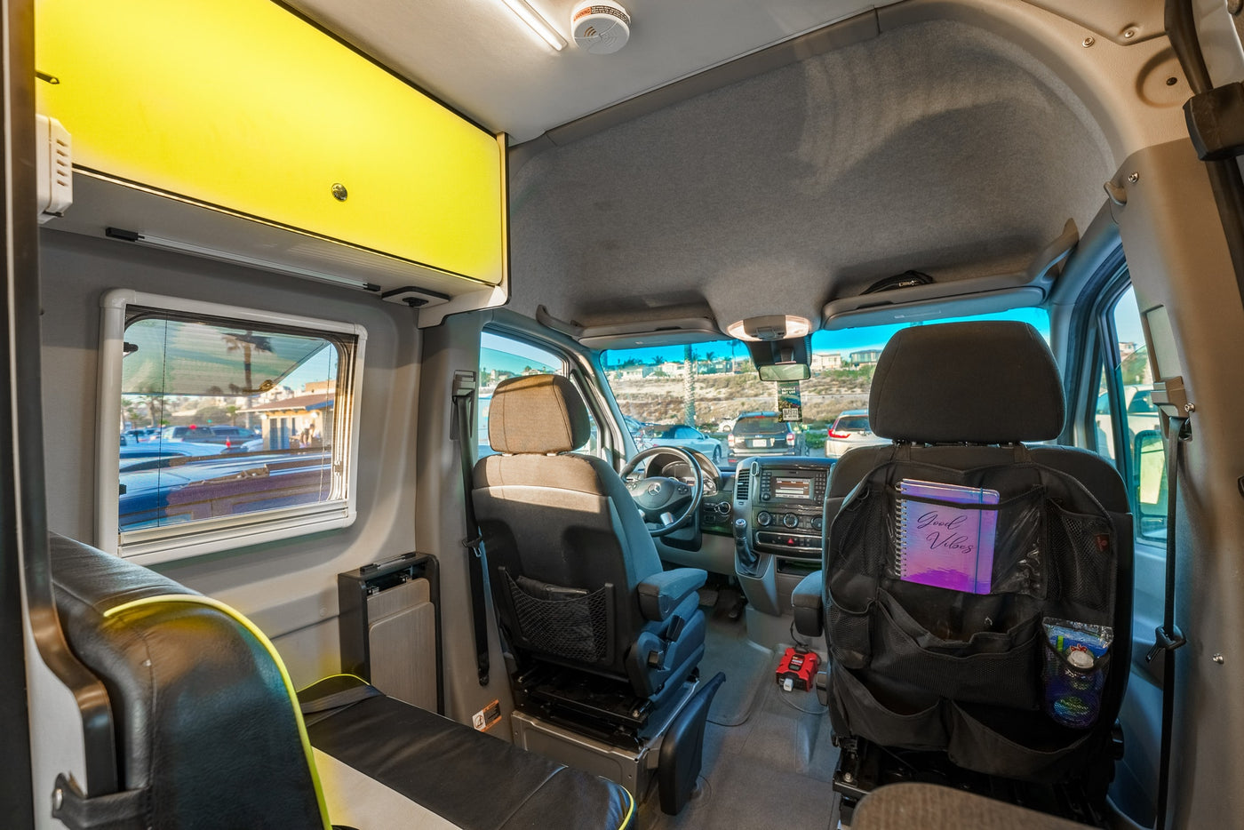 Inside an rv rental: spacious camper van interior with front cockpit, seats, and overhead storage. — photo 12