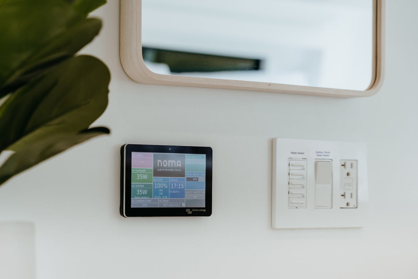 RV rental digital control panel displays energy, battery, and tank levels next to water heater switches. — photo 15
