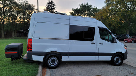 White Sprinter-style camper van, an ideal RV rental, featuring a rear storage box.