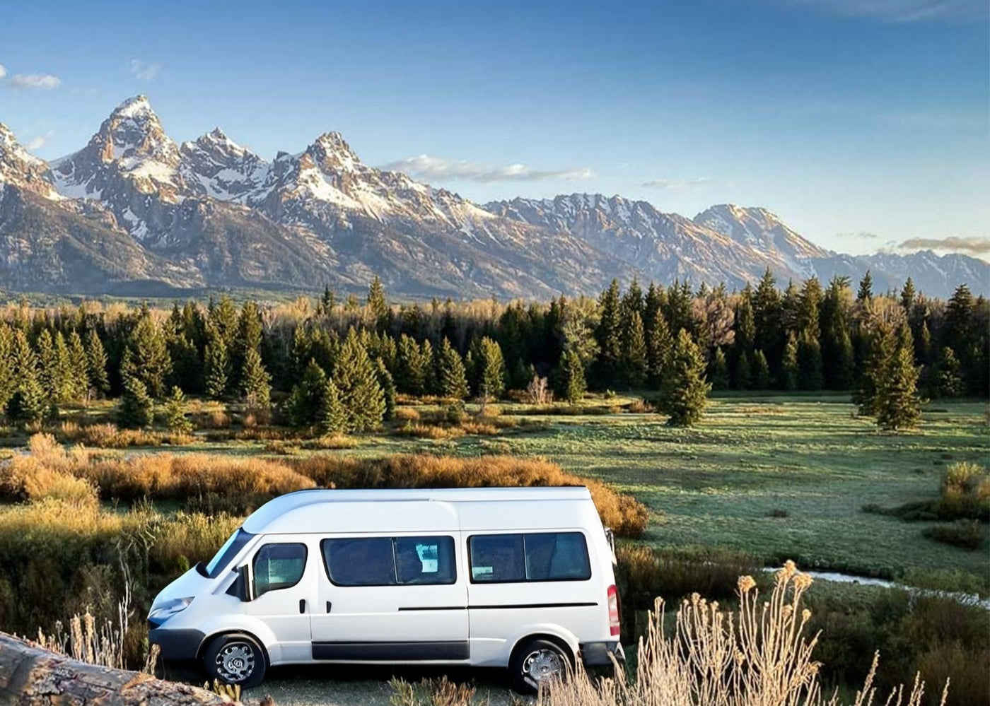  with mountains and a picnic area under a blue sky.|White RV rental at Grand Teton NP