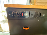 RV rental's control panel: Switches for inverter, fridge, water pump, lights, and toilet. Also, a battery monitor, outlets, and climate controls.