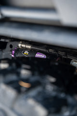 Close-up of a dusty Dobinsons suspension shock with purple accents, enhancing your RV rental's off-road capability.