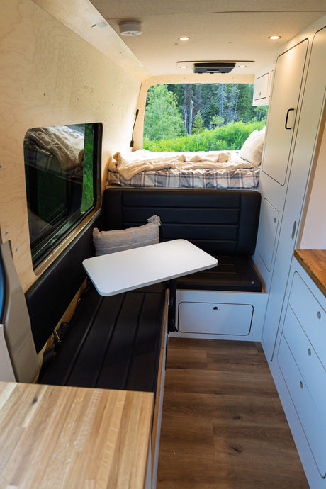 Experience van life! This modern rv rental offers a functional interior with a comfy bed, dinette, and panoramic views of nature.
