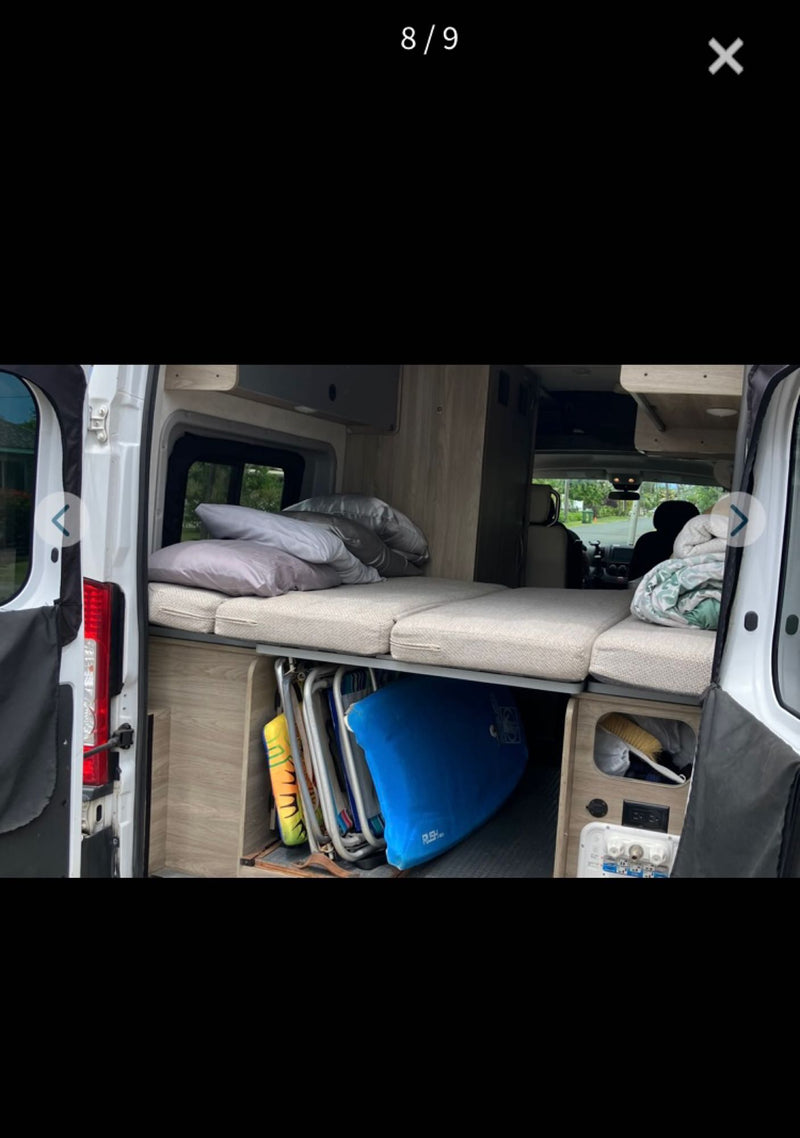 RV rental interior: comfy bed, clever under-bed storage for gear like chairs and boards, plus power outlets. Ready for travel. — photo 8