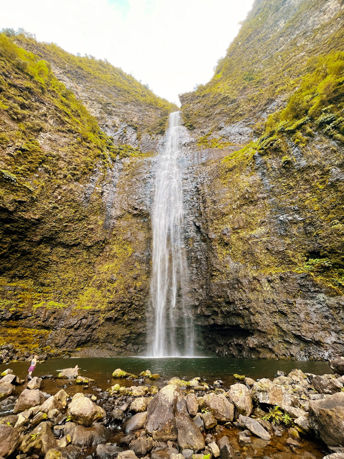 A tall waterfall descends into a dark pool, bordered by rocky, moss-covered cliffs. Ideal for an RV rental getaway. — photo 13