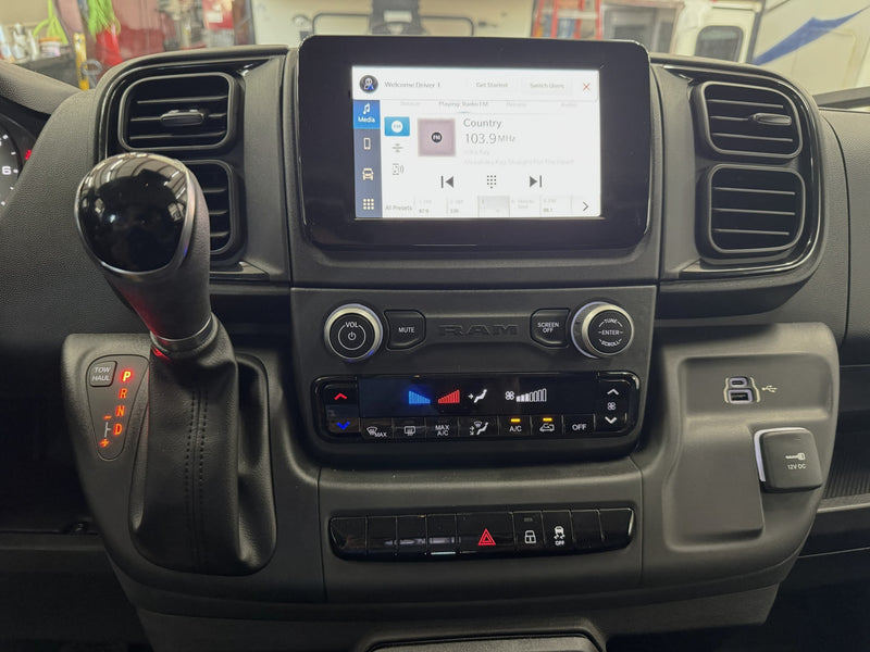 RV rental's dashboard: Infotainment screen (103.9 MHz), gear shifter, climate control, and charging ports. — photo 8