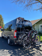 Stylish gray RV rental camper van with a rear bike rack holding two electric bikes, ready for an outdoor getaway.
