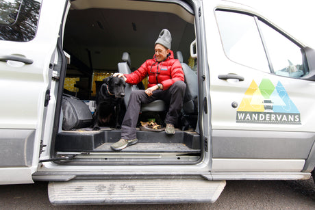 This RV rental shows a man and his dog relaxing in a WANDERVANS camper van, ideal for pet-friendly travel.