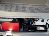RV rental power setup: A large red Lithionics battery and Xantrex inverter manage off-grid electrical needs.