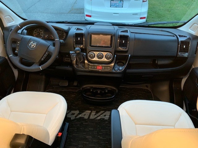 Inside this modern camper van RV rental: A detailed cockpit view featuring white front seats, steering wheel, and dashboard. — photo 7
