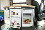 Inside this RV rental, a compact, well-stocked refrigerator and kitchenette are ready for travel.