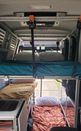 An RV rental camper's interior showcases a suspended top bunk and two lower beds, ideal for multi-person sleeping.