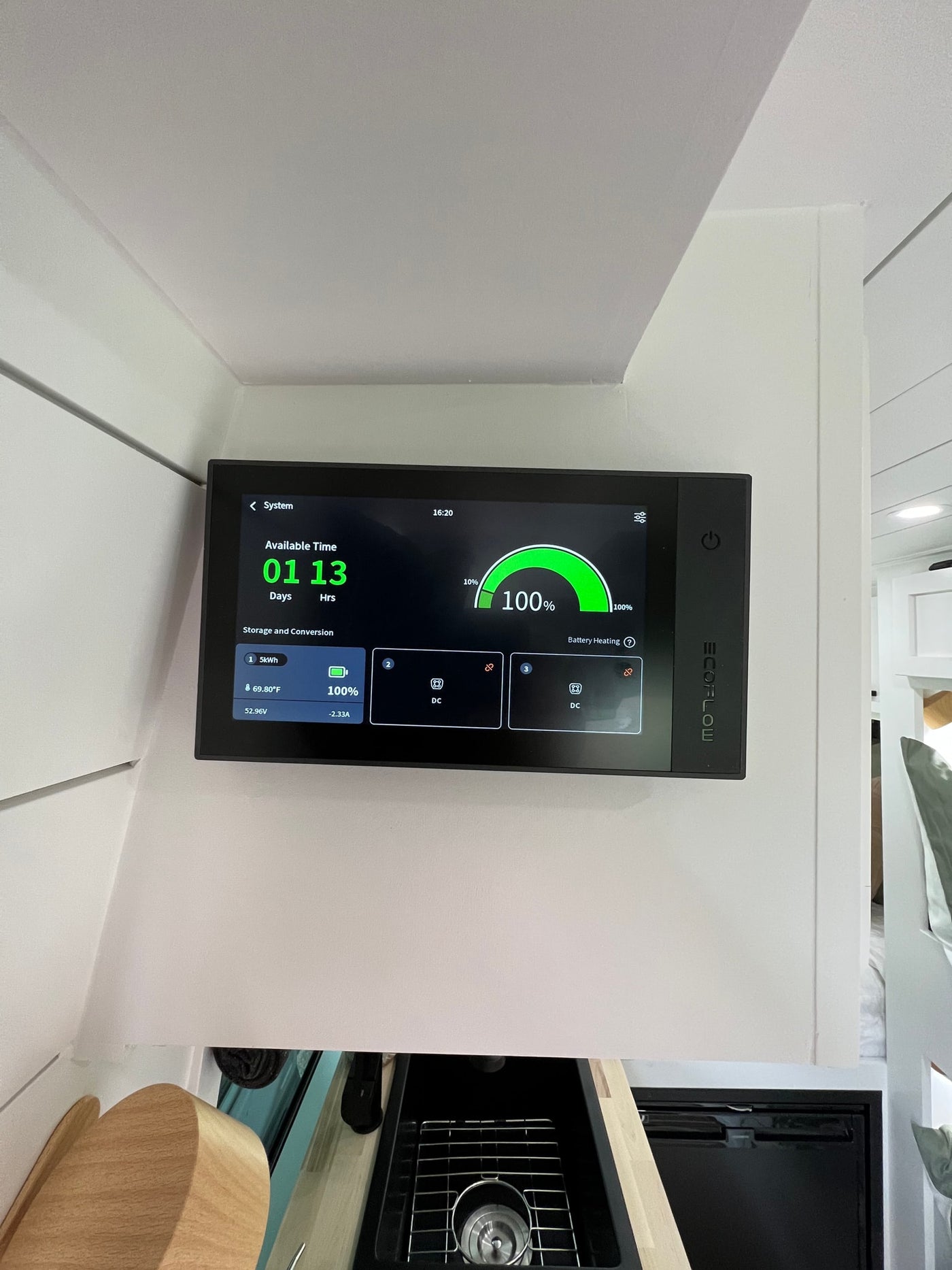 In an rv rental, an EcoFlow power monitor displays 100% battery (5kWh) with 1 day, 13 hours of available runtime, at 69.8°F. — photo 20
