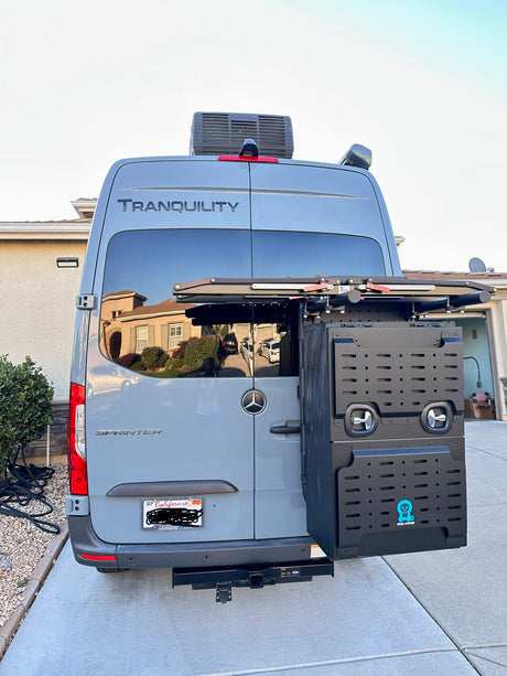 Back of a custom grey Mercedes Sprinter RV rental, with a roof AC, rear cargo box, and bike rack for adventure.