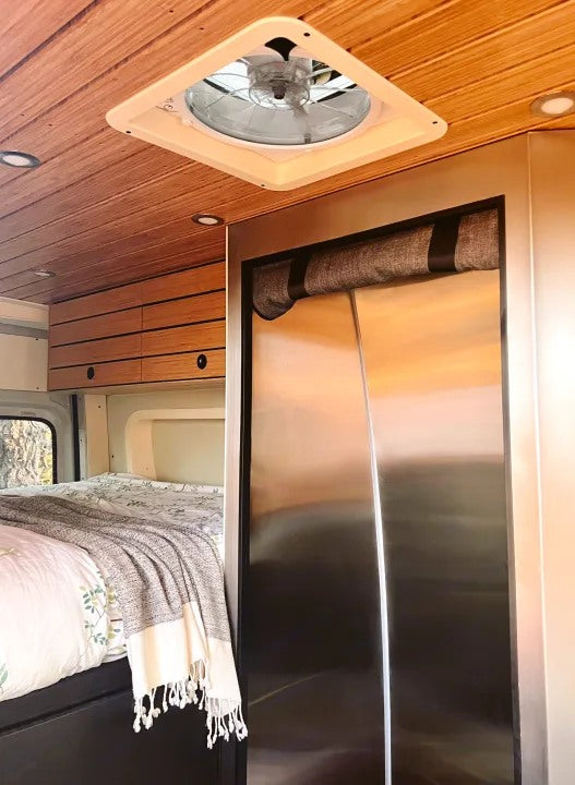 RV rental bedroom area: wood-paneled ceiling, vent fan, recessed lights, and comfy bed. Stainless fridge and cabinets too.