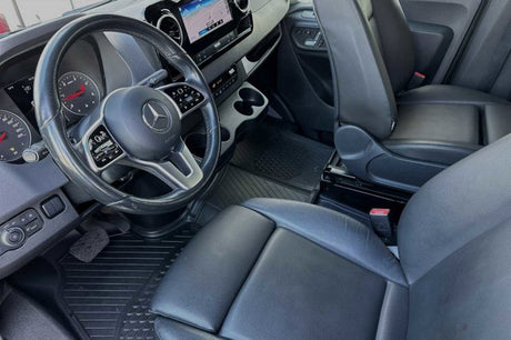 Inside a Mercedes-Benz van for rv rental: sleek dashboard, comfortable leather seats, and durable floor mats.