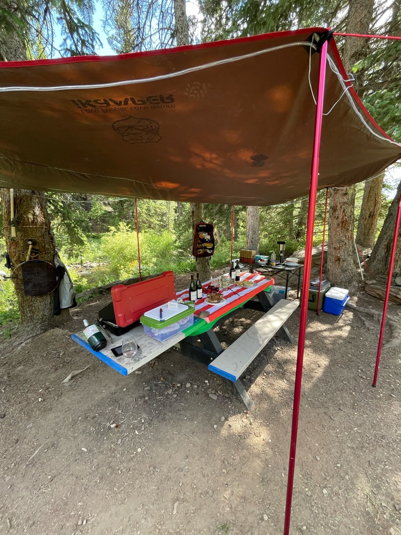 Cozy RV rental camp setup: Enjoying an outdoor picnic & cookout under a spacious awning by the stream. — photo 13