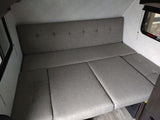 RV rental: The gray convertible dinette/bed in this camper's compact interior offers versatile seating and sleeping.