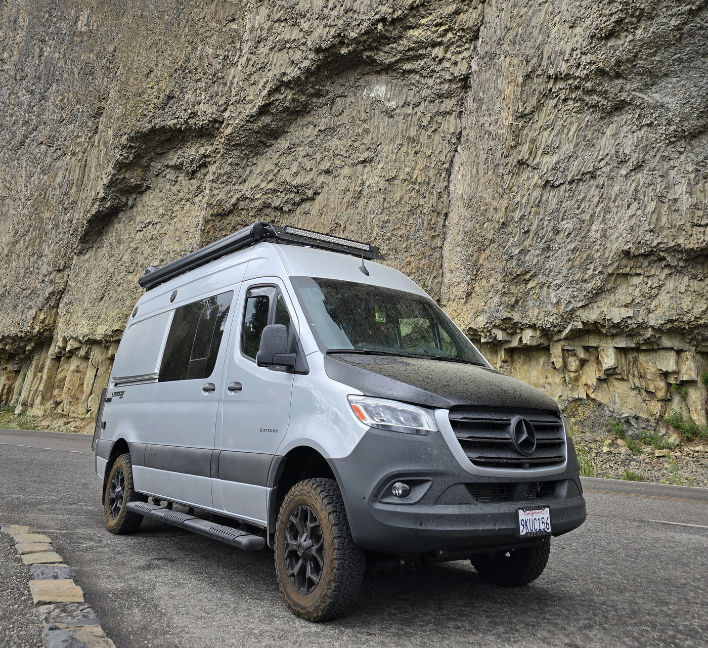 A gray Mercedes Sprinter rv rental, equipped for adventure, parked alongside a magnificent columnar basalt cliff. — photo 10