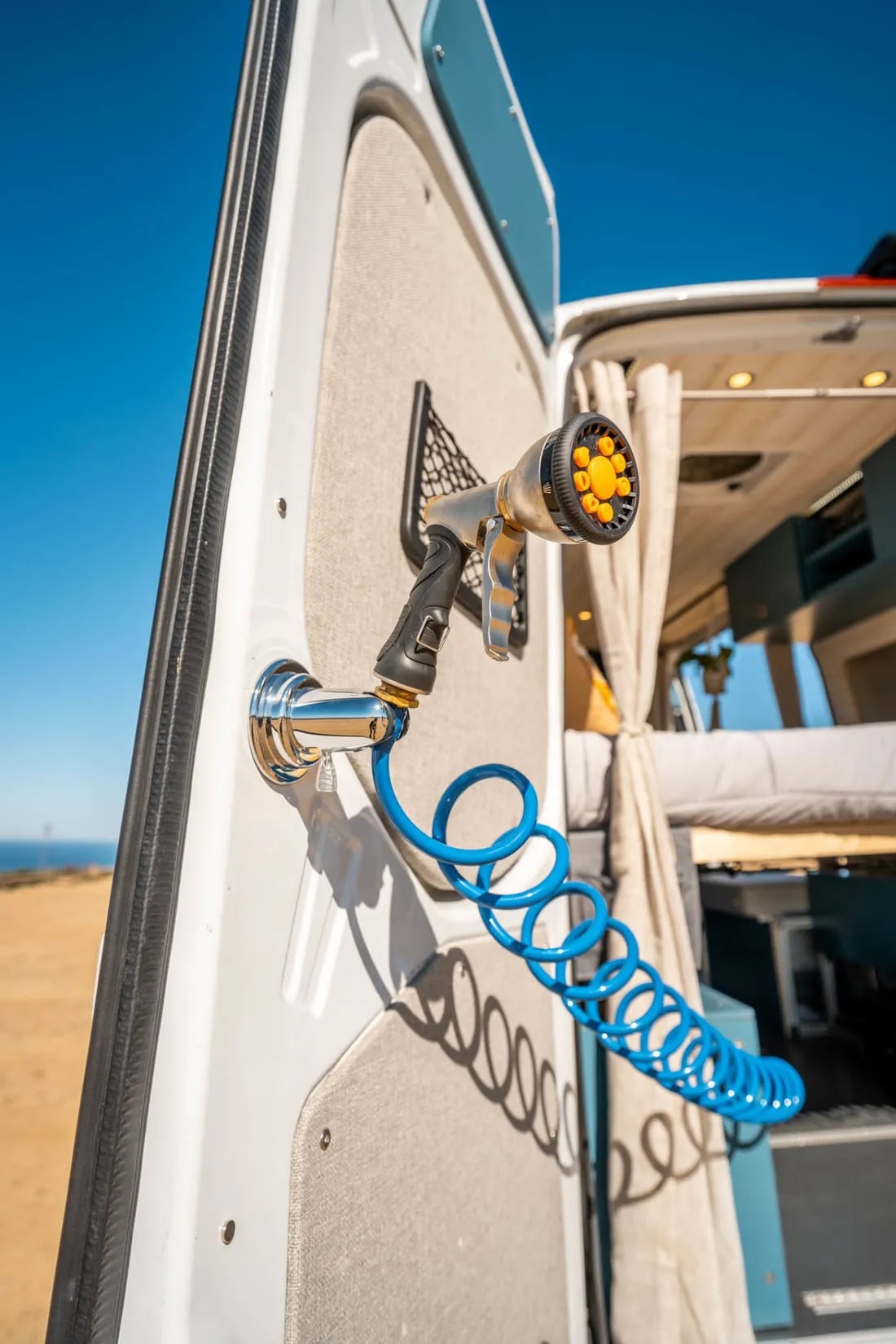  and bottle. Ideal for van life essentials.|Inside an RV rental: blue shelves with coffee items & dishes above a tiled kitchen backsplash and sink.|Organized kitchen drawer in an RV rental — photo 15