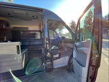 RV rental: See inside this spacious camper van with open doors, revealing its comfortable interior on a bright, sunny day.