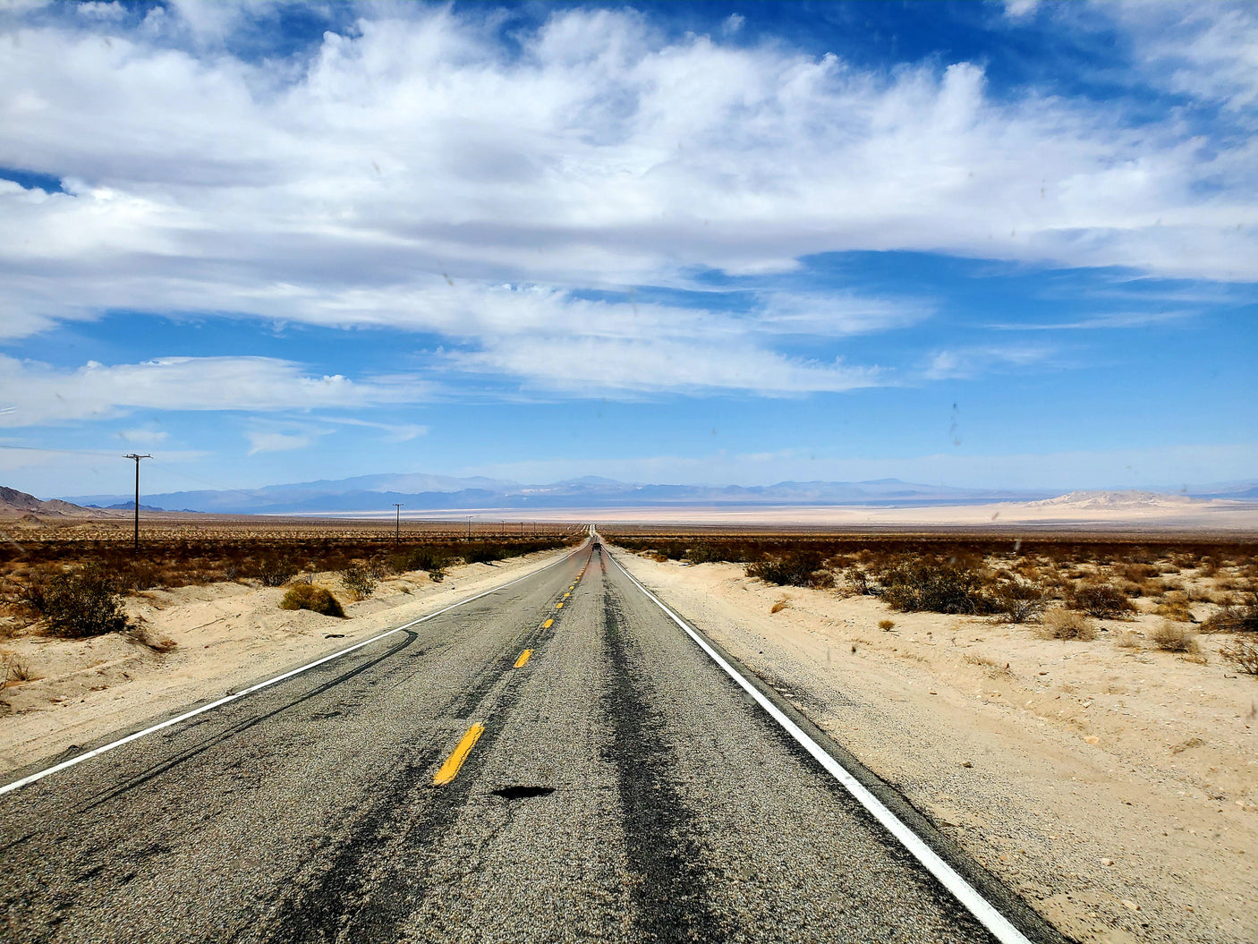 Long desert road under blue skies, perfect for an RV rental adventure.