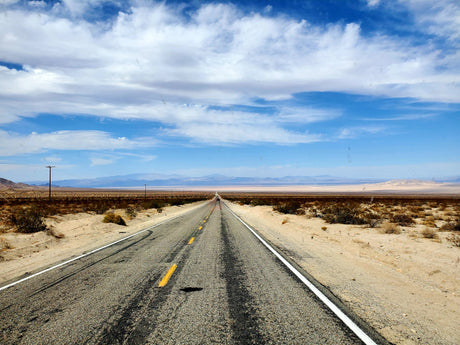Long desert road under blue skies, perfect for an RV rental adventure.
