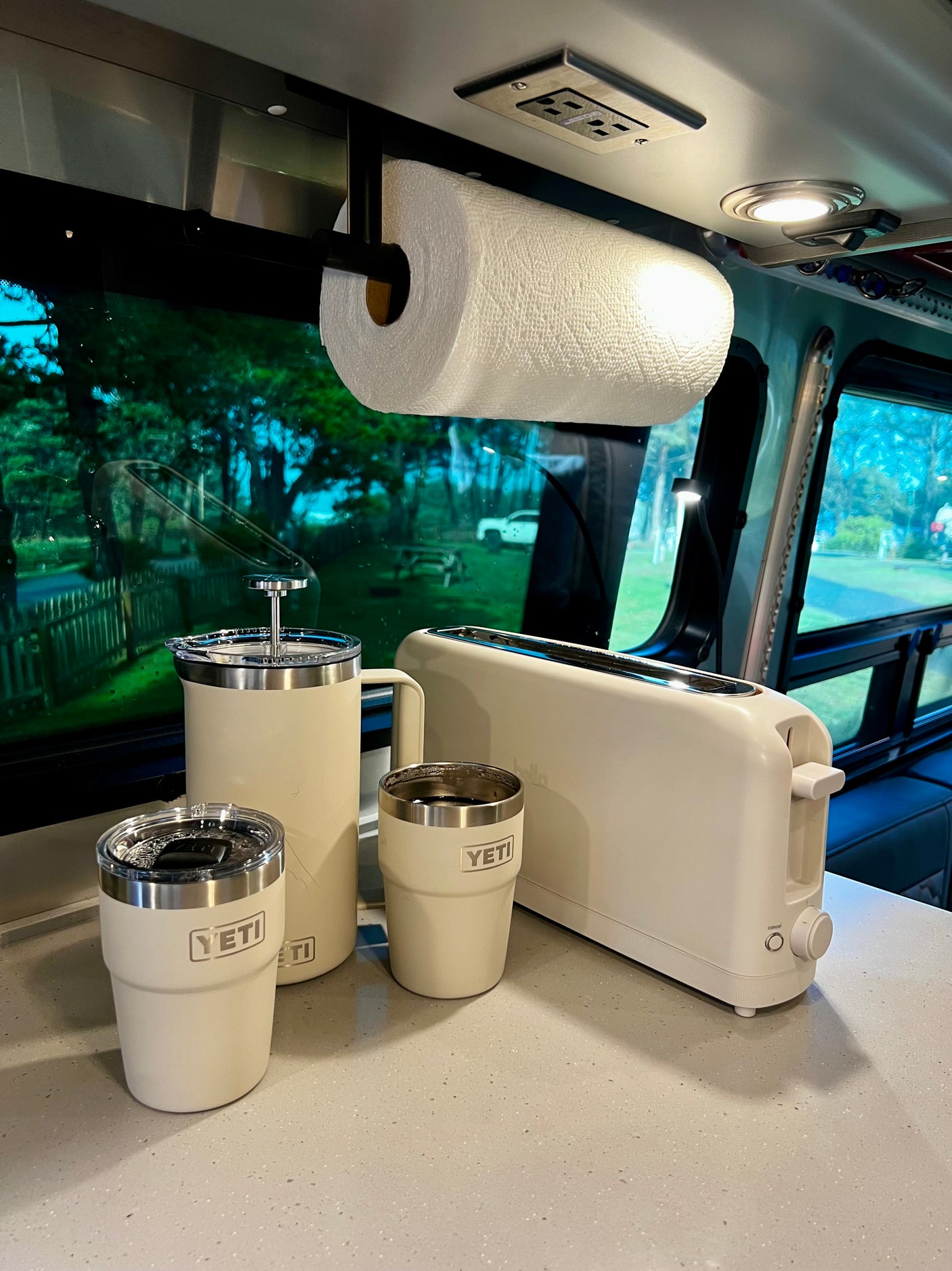 Cozy RV rental kitchen featuring YETI tumblers, coffee press, toaster, and paper towels for convenient travel.