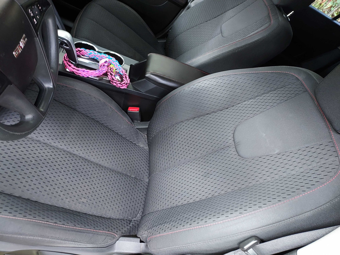 GMC vehicle interior with dark fabric seats, steering wheel, & console. Comfortable, great for an RV rental trip.