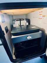 RV rental: Interior storage bay with a portable cooler/fridge, organized gear, and a mounted bottle opener.