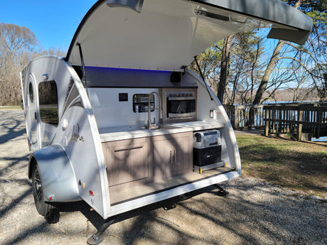 Explore with this Luna teardrop RV rental! Its open rear galley kitchen, with sink, microwave, & cooler, is lakeside ready.