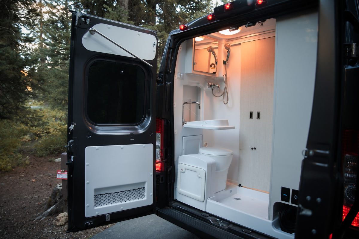 Compact RV rental van opens to reveal a well-equipped bathroom with shower, toilet, and sink for adventures. — photo 18