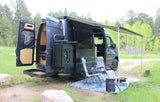 **RV rental** van parked with an extended awning, chairs, and fire pit for a cozy outdoor camping setup.