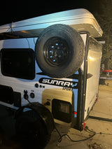 Explore the outdoors with this white Sunray Sport compact travel trailer, featuring a rooftop tent & spare tire. Ideal for RV rental adventures.