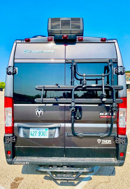 Rear view of a gray RV rental campervan with bike rack, rooftop AC, and Illinois plate. Ready for travel!