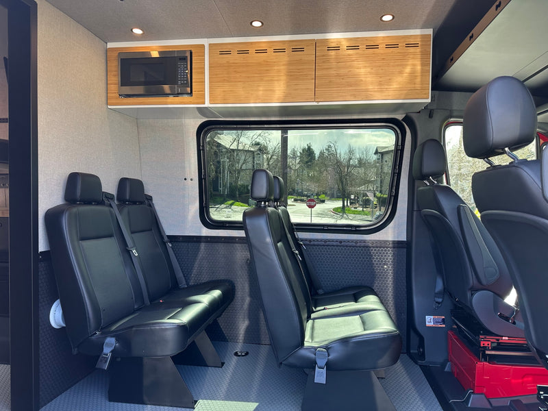 Spacious RV rental interior featuring passenger seating, microwave, and bamboo cabinetry for comfortable travel. — photo 6