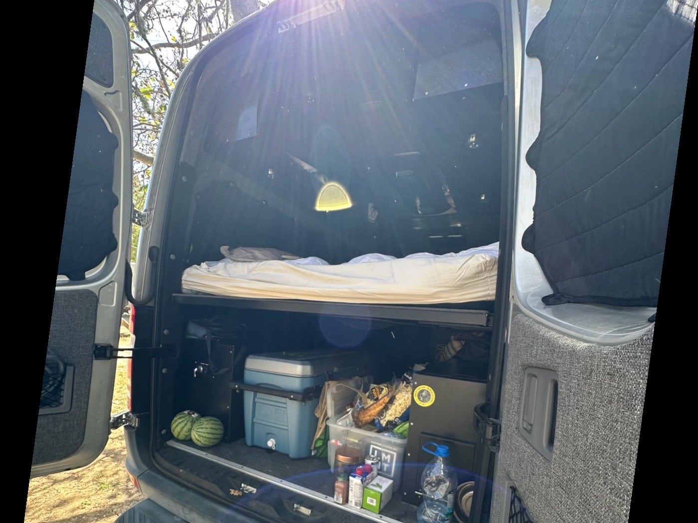  and overhead compartments.|RV rental interior: A comfortable bed with striped cushions