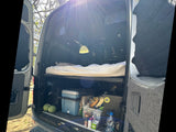  and overhead compartments.|RV rental interior: A comfortable bed with striped cushions