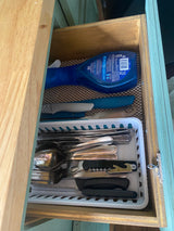 RV rental kitchen drawer with organized utensils, kitchen knives, and Dawn dish soap spray for easy cleaning.