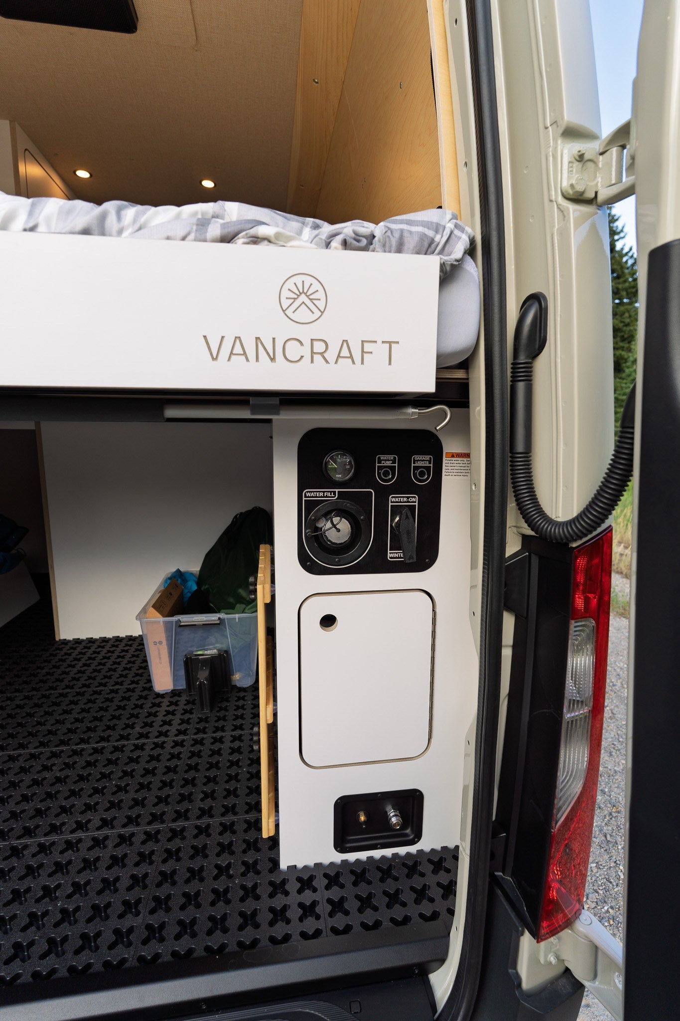  and a wooden counter with power outlets.|Inside an RV rental: a custom campervan interior with a lift-up bench seat for storage — photo 2