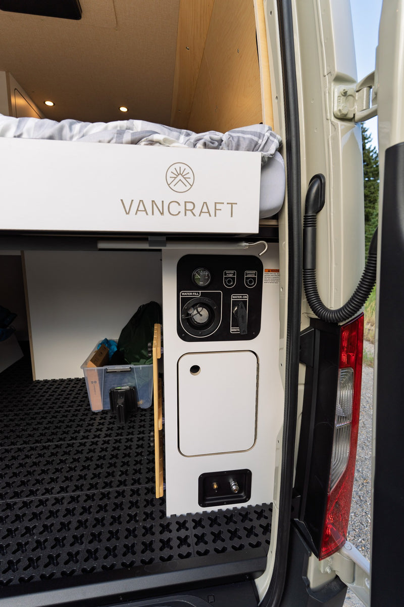  and a wooden counter with power outlets.|Inside an RV rental: a custom campervan interior with a lift-up bench seat for storage — photo 2