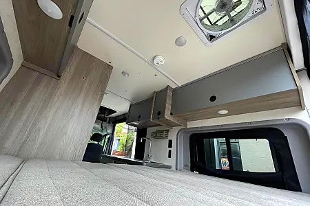  and a mesh screen at the rear entrance.|Interior view of a modern RV rental. Features include a comfortable bed — photo 3