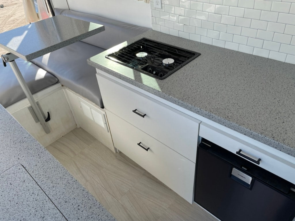  and scenic lake & mountain view.|Modern RV rental interior: compact kitchen with gray counters — photo 7