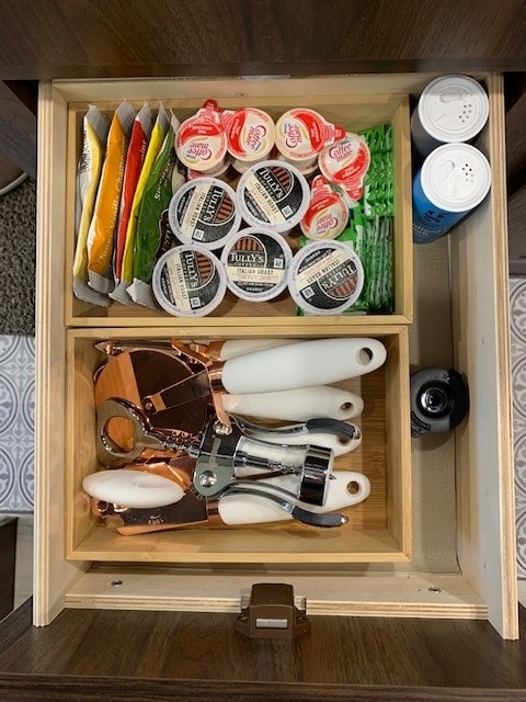 Well-organized RV rental drawer: coffee pods, creamers, drink packets, and essential kitchen tools like can openers. — photo 14