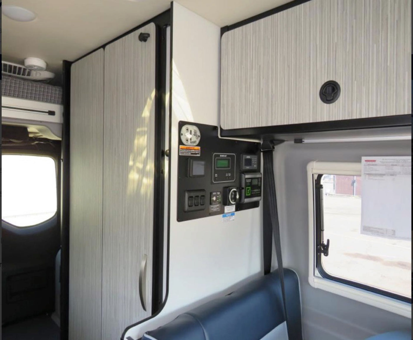  and front cabin are visible from the rear.|Inside a Mercedes-Benz Sprinter RV rental: view of driver's area with steering wheel — photo 11