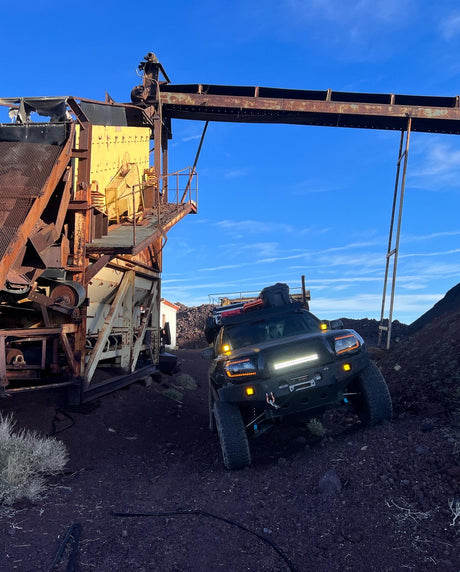Off-road truck explores a rusty industrial site. More rugged than an RV rental, it's built for adventure!