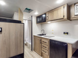 This RV rental boasts an efficient layout with a modern kitchen, built-in fridge, microwave, a cozy bed, and private shower.