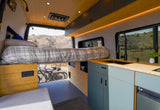This RV rental shows a modern van interior with a raised bed, under-bed bike storage, and a sleek kitchenette.