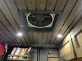 RV rental interior: Wooden ceiling with fan, lights, and a bookshelf filled with books. A cozy van life setup.
